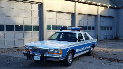 1991 Ford LTD Crown Victoria - Metropolitan Police Ford Crown Victoria parked in front of garage doors.