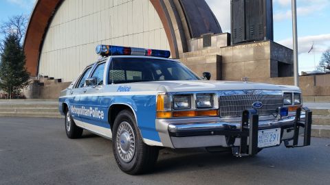 1991 Ford LTD Crown Victoria - A 1991 Ford Crown Victoria police car is parked in front of a building with a curved facade.