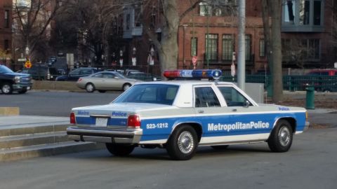 1991 Ford LTD Crown Victoria - A police car with 'Metropolitan Police' text and emergency lights is parked on the street.