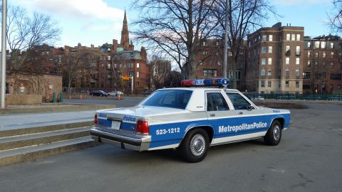 1991 Ford LTD Crown Victoria - A 1991 Ford Crown Victoria police car is parked on a street with buildings in the background.