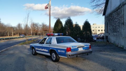 1991 Ford LTD Crown Victoria - Metropolitan Police Ford Crown Victoria parked outdoors, showing its rear and side details.