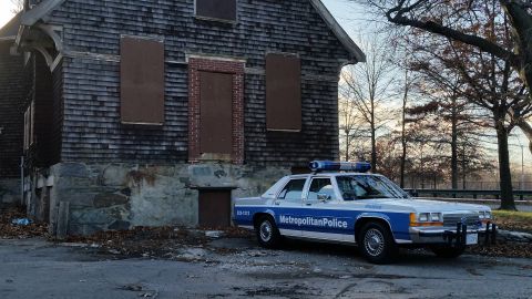 1991 Ford LTD Crown Victoria - Metropolitan Police Crown Victoria parked next to an abandoned building.