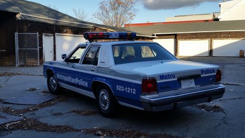 1991 Ford LTD Crown Victoria - This 1991 Ford Crown Victoria police car is seen from the rear 3/4 angle, displaying its silver and blue livery.