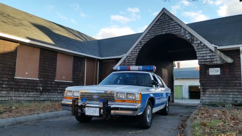 1991 Ford LTD Crown Victoria - Police car parked in front of an old building with a distinctive arched entryway.
