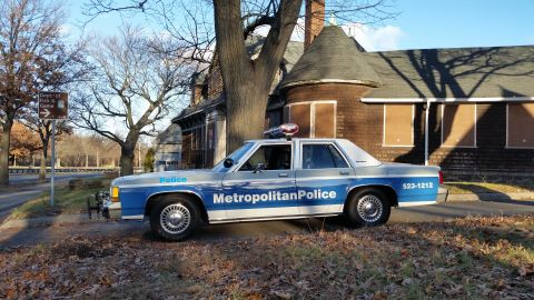 1991 Ford LTD Crown Victoria - A 1991 Ford Crown Victoria police car is parked in front of an abandoned building.