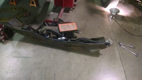 2000 Chevrolet Astro - A disassembled vehicle dashboard and air intake system lies on a concrete floor, with tools scattered around.