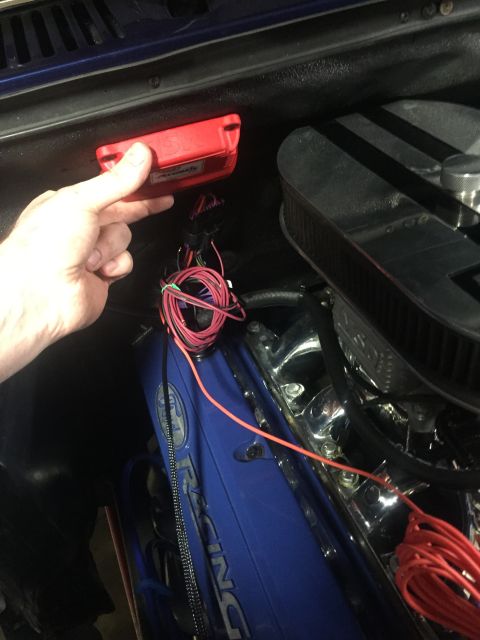 1982 Ford Bronco - Close-up of engine bay wiring and a red electronic module being held.