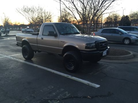 1991 Ford Bronco - A tan Ford Ranger pickup truck is parked in a lot with other vehicles visible in the background.