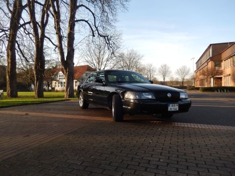 2003 Mercury Marauder - A black 2003 Mercury Marauder is seen from a 3/4 front angle, parked on a brick-paved area with trees and buildings in the background.