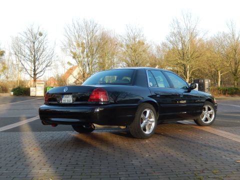2003 Mercury Marauder - A black 2003 Mercury Marauder is parked on a brick-patterned surface with trees in the background.