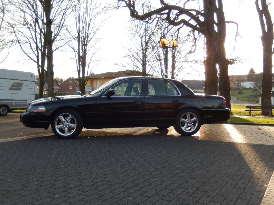 Side view of a black 2003 Mercury Marauder parked on a brick-patterned surface