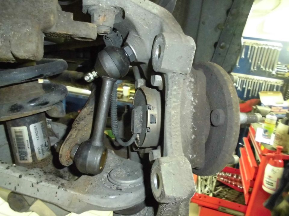 Close-up of a vehicle's suspension linkage and brake rotor
