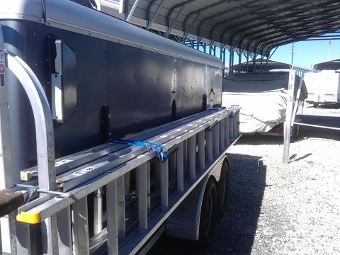 1994 Ford Bronco - A trailer equipped with a ladder rack holds several aluminum ladders.