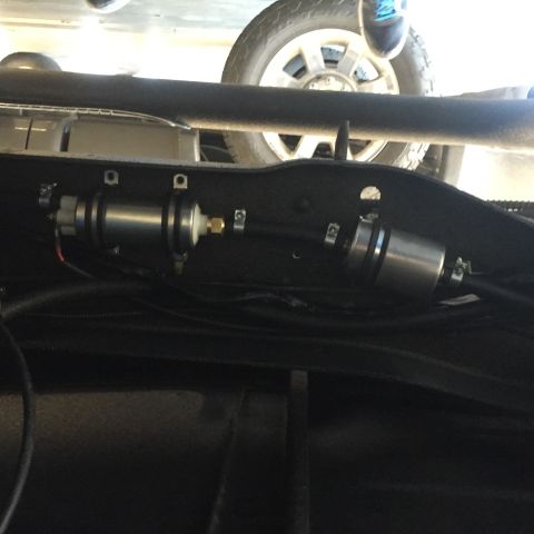 1982 Ford Bronco - Close-up view of the fuel filter and pump assembly mounted under the vehicle's frame.