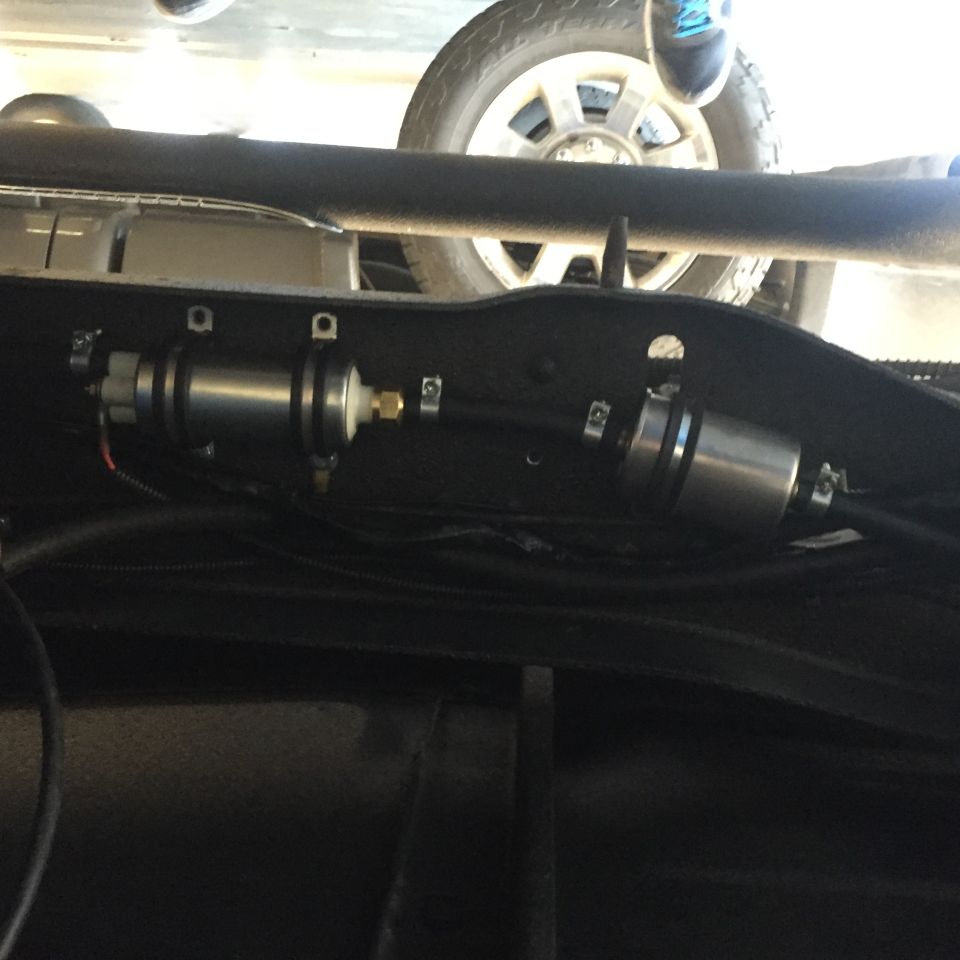 underneath vehicle showing fuel filter and pump assembly, tire visible