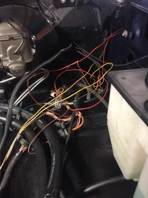 1982 Ford Bronco - A close-up view of the engine bay of a 1982 Ford Bronco, showing a complex wiring harness with red, yellow, and orange wires near the brake…