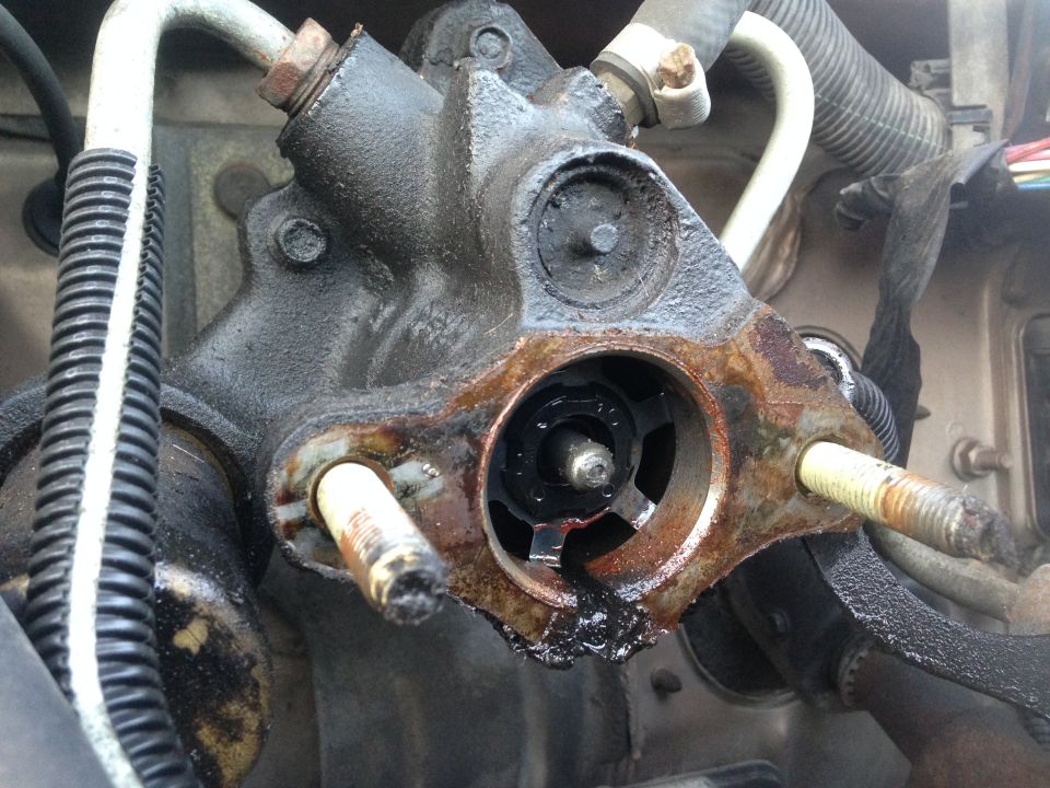 Close-up of a rusty hydroboost brake unit with black fluid leakage