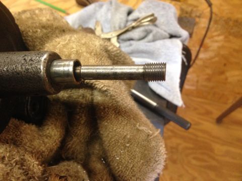 1979 Ford Bronco - A threaded metal rod is shown extending from a tool, with a brown cloth underneath.