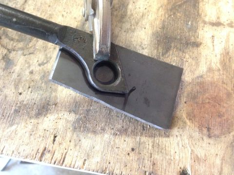 1979 Ford Bronco - A metal component is being worked on with a clamp and cutting tool on a weathered wooden surface.
