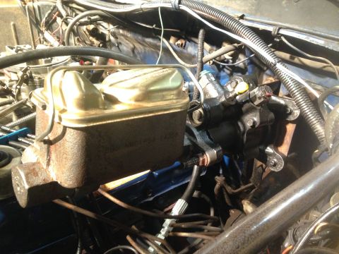1979 Ford Bronco - Close-up view of the master cylinder and brake booster assembly within the engine compartment.