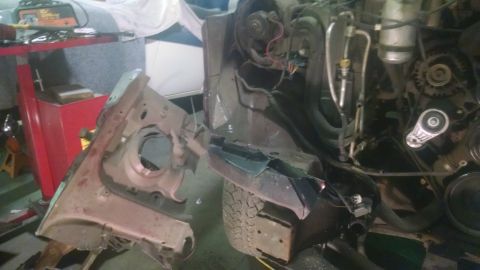 2000 Chevrolet Astro - Vehicle engine and front end disassembled, with parts removed and body damage visible.