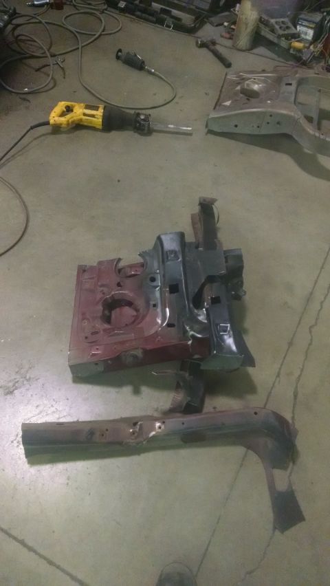 2000 Chevrolet Astro - Disassembled vehicle frame components and a power tool are laid out on a concrete floor in a workshop.