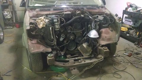 2000 Chevrolet Astro - Disassembled engine bay of a vehicle, with parts and tools scattered around.