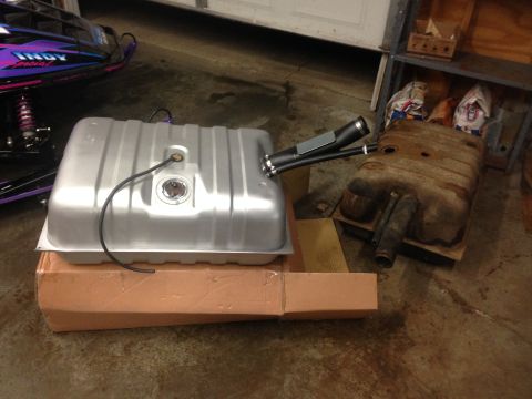 1979 Ford Bronco - Comparing a new fuel tank with an old, rusted one in a garage setting.