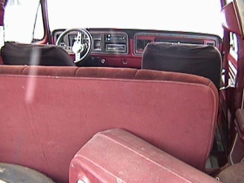 1995 Ford Bronco - The interior of this classic Ford Bronco features red upholstery and a dashboard with a retro radio.