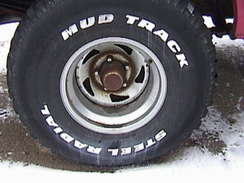 1995 Ford Bronco - A close-up view of a tire with "Mud Track" and "Steel Radial" written on it, mounted on a vehicle's wheel.