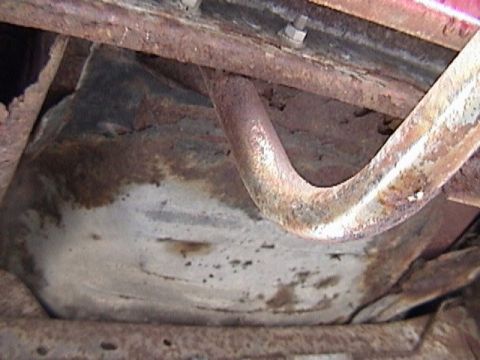 1995 Ford Bronco - Close-up of a heavily rusted vehicle undercarriage and exhaust pipe.