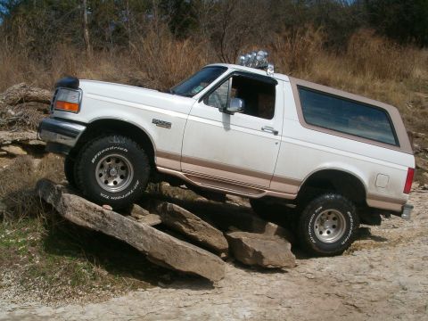 1996 Ford Bronco - This 1996 Ford Bronco navigates a rocky trail with its distinctive two-tone paint and off-road tires.