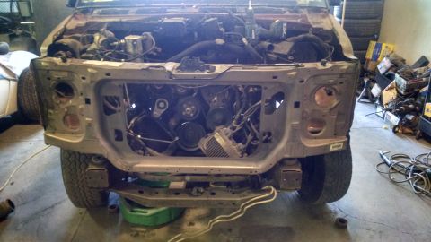 2000 Chevrolet Astro - The front end of a disassembled vehicle, likely a Chevrolet Astro van, is shown with the hood and front clip removed, exposing the engine a…