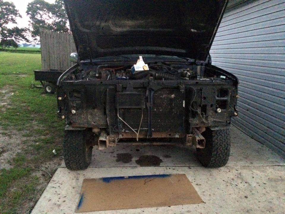 1994 Ford Bronco front view, hood open, engine exposed, parked in front of garage.