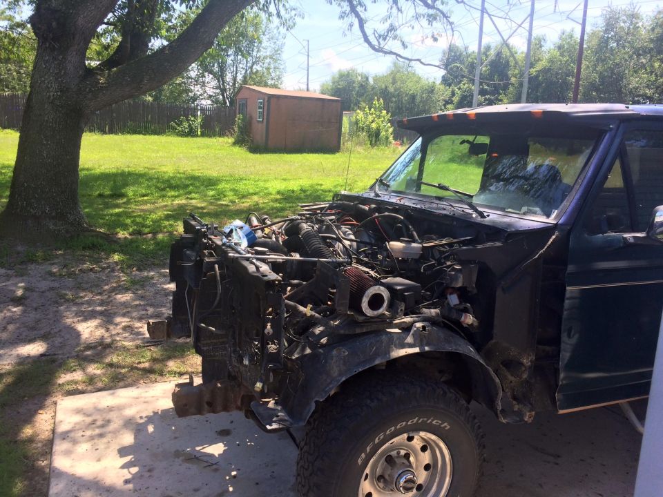 1994 Ford Bronco with hood open, engine exposed, parked outdoors.