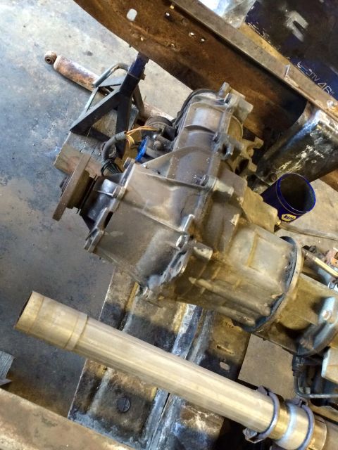 1994 Ford Bronco - A close-up, high-angle shot shows a transfer case and transmission assembly, likely from a 1994 Ford Bronco, mounted on a metal frame. A se…