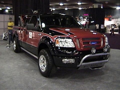 1995 Ford Bronco - This modified Ford F-150 pickup truck is displayed indoors, possibly at a car show.