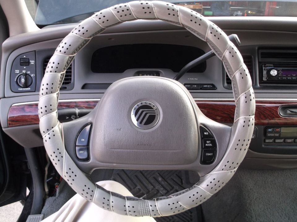 Interior of a 2001 Mercury Grand Marquis, showing steering wheel with cover and dashboard.