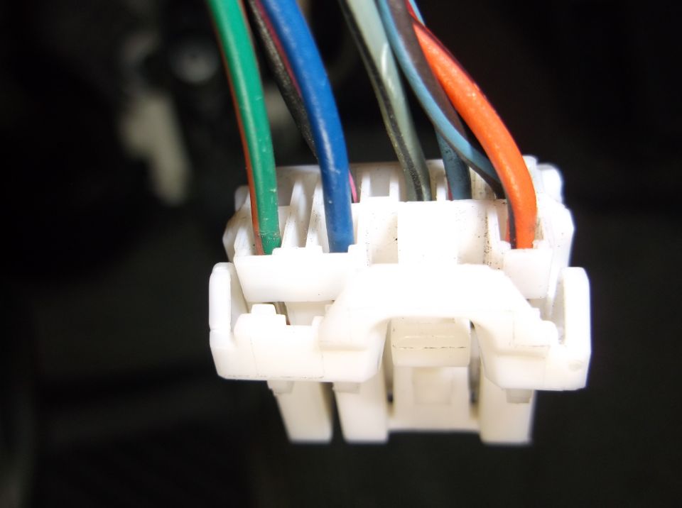 White electrical connector with green, blue, black, gray, and orange wires