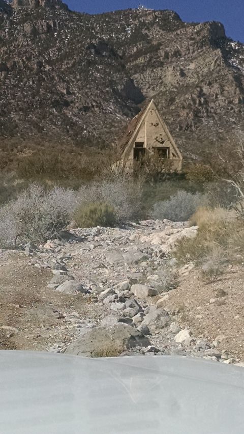1979 Ford Bronco - A triangular, abandoned structure sits on a rocky hillside under a large mountain.