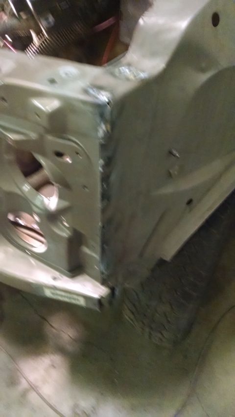 2000 Chevrolet Astro - A close-up, angled view shows the metal body panels of a vehicle, possibly a van or SUV, in a workshop setting. Welds are visible along a s…