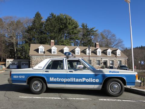 1991 Ford LTD Crown Victoria - Photo of a Metropolitan Police Ford Crown Victoria parked in front of a stone building.