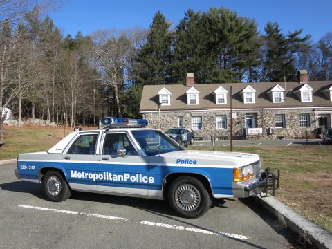 1991 Ford LTD Crown Victoria - Photo of a Metropolitan Police Ford Crown Victoria parked in front of a stone building.