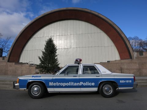 1991 Ford LTD Crown Victoria - A 1991 Ford Crown Victoria police car is seen from the side in front of a large archway.