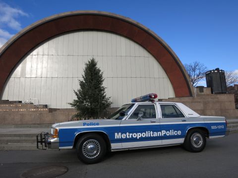 1991 Ford LTD Crown Victoria - Side view of a 1991 Ford Crown Victoria police car parked in front of a building.