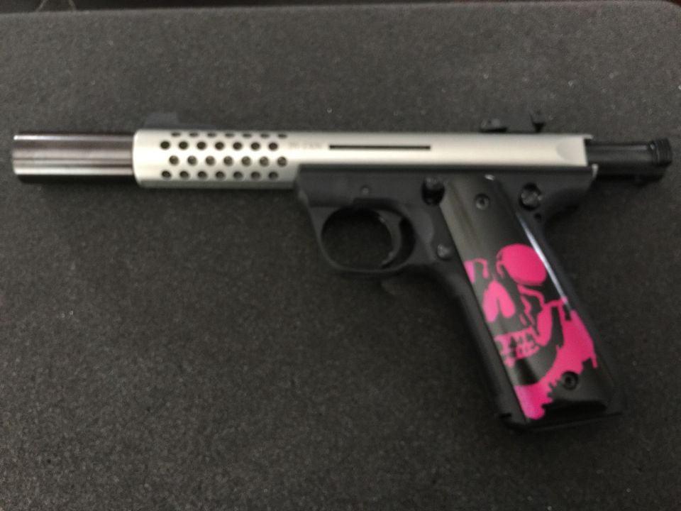 Semi-automatic pistol with perforated barrel shroud and pink skull grips.