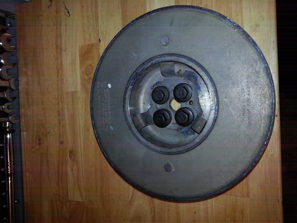 Metal damper assembly with warning text and Cummins part number.