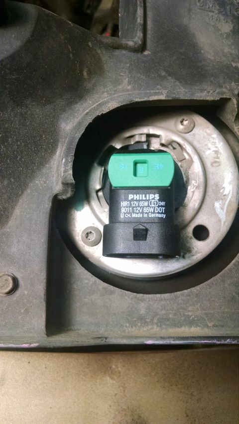 2000 Chevrolet Astro - A close-up view of a Philips HIR1 12V 65W headlight bulb installed in a vehicle's headlight housing. The bulb has markings indicating it is…