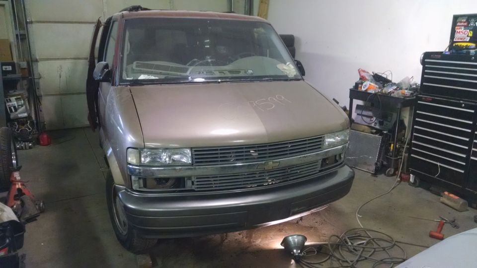 2000 Chevrolet Astro van front view in a garage, hood open, two-tone brown and maroon.