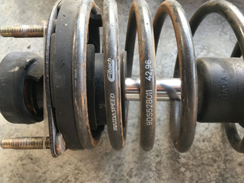 Close-up of a suspension coilover with Eibach and Mazdaspeed branding.